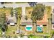 Aerial view of a home with a backyard pool, patio area, and mature landscaping and driveway at 7997 Kaitlin Cir, Lakeland, FL 33810