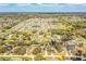 Expansive aerial view of a residential neighborhood with homes, trees, and a community pond on a bright day at 7997 Kaitlin Cir, Lakeland, FL 33810