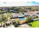 Aerial view of a backyard with a pool, covered patio, wooden fence, and mature trees at 7997 Kaitlin Cir, Lakeland, FL 33810