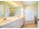 Bathroom featuring a soaking tub, walk-in shower, and dual vanity at 7997 Kaitlin Cir, Lakeland, FL 33810