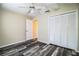 This bedroom features wood-look flooring, a ceiling fan, and a closet with bi-fold doors at 7997 Kaitlin Cir, Lakeland, FL 33810