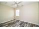 Neat bedroom with wood-look floors, neutral walls, ceiling fan, and a window, creating a cozy ambiance at 7997 Kaitlin Cir, Lakeland, FL 33810