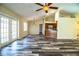 Spacious living room and kitchen area featuring a ceiling fan and back door access at 7997 Kaitlin Cir, Lakeland, FL 33810