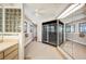 A light tiled bathroom with black shower, glass block window, vanity, and ample towel racks at 949 Success Ave, Lakeland, FL 33801