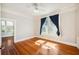 This light filled bedroom features hardwood floors, white trim, and a ceiling fan at 949 Success Ave, Lakeland, FL 33801