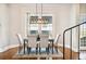 Elegant dining room with modern light fixture, hardwood floors, and large windows overlooking the property at 949 Success Ave, Lakeland, FL 33801