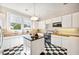 Clean kitchen featuring custom cabinets, stylish lighting, black and white checkered floor, and countertops at 949 Success Ave, Lakeland, FL 33801