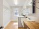 Functional laundry room with storage shelves, tile flooring, and a utility sink at 949 Success Ave, Lakeland, FL 33801