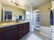 Well-lit bathroom featuring double sinks, a bathtub, and a shower with stylish fixtures at 1134 Legatto Loop, Dundee, FL 33838