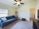 This bedroom features neutral walls, carpeted floor, ceiling fan and a blue sofa at 1134 Legatto Loop, Dundee, FL 33838