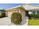 Charming home featuring a well-maintained lawn, beige exterior, and attached garage at 1134 Legatto Loop, Dundee, FL 33838