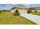 Beige exterior, 2-car garage and a well-manicured lawn of this single story home at 1134 Legatto Loop, Dundee, FL 33838