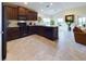 Well-lit kitchen featuring dark cabinetry, modern appliances, and tiled floors at 1134 Legatto Loop, Dundee, FL 33838