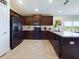Modern kitchen featuring black appliances, dark wood cabinets, and sleek countertops with tile floors at 1134 Legatto Loop, Dundee, FL 33838