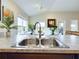 A stainless steel double kitchen sink with a view to the backyard at 1134 Legatto Loop, Dundee, FL 33838