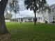 Lush backyard with a large, open grassy area, partially shaded by trees, ideal for recreation and tranquility at 117 Tremont Dr, Winter Haven, FL 33884