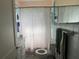 Cozy bathroom featuring a tiled shower with seashell themed shower curtain and a white vanity at 117 Tremont Dr, Winter Haven, FL 33884