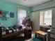 Comfortable bedroom featuring light blue walls, window with white curtains, and a dresser with accessories at 117 Tremont Dr, Winter Haven, FL 33884