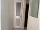 Hallway featuring a white louvered door, light walls, and a mirror at 117 Tremont Dr, Winter Haven, FL 33884