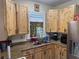 Updated kitchen with knotty wood cabinets, stainless steel appliances, and granite countertops at 117 Tremont Dr, Winter Haven, FL 33884