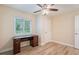 Bright bedroom featuring wood-look floors, ceiling fan and built-in desk at 1317 Bramblewood Dr, Lakeland, FL 33811