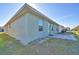 Rear view of a light green house, showcasing a small patio and grassy backyard at 136 Krenson Bay Loop, Winter Haven, FL 33881