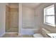Well-lit bathroom showcasing a glass door shower and a soaking tub by the window at 136 Krenson Bay Loop, Winter Haven, FL 33881