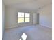 A bright bedroom featuring neutral carpet and a large window, offering ample natural light at 136 Krenson Bay Loop, Winter Haven, FL 33881
