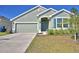 Charming single-Gathering home features a well-manicured lawn, two-car garage, and neutral-toned exterior paint at 136 Krenson Bay Loop, Winter Haven, FL 33881