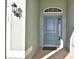 Close-up of a stylish blue front door with sidelight window and decorative transom window at 136 Krenson Bay Loop, Winter Haven, FL 33881