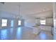 Open living space showcasing tile floors, modern chandelier, and seamlessly connected kitchen at 136 Krenson Bay Loop, Winter Haven, FL 33881