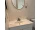Bathroom vanity with white basin sink, oval mirror, and towel rack, offering a functional space at 141 Fernery Rd # B5, Lakeland, FL 33809
