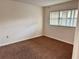 Bedroom with neutral walls, carpet flooring, and a window providing natural light at 141 Fernery Rd # B5, Lakeland, FL 33809