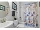 Well-lit bathroom with a vanity, toilet and shower/tub combo with stylish seashell shower curtain at 1420 Mickelson Ct, Davenport, FL 33896