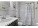 Bright bathroom featuring a large mirror, floral shower curtain, and white tiled walls at 1420 Mickelson Ct, Davenport, FL 33896