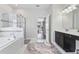 Bright bathroom featuring walk-in shower, soaking tub, dark vanity and neutral tile at 1420 Mickelson Ct, Davenport, FL 33896