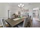 Bright dining room featuring a chandelier, hardwood floors, and views into the living room at 1420 Mickelson Ct, Davenport, FL 33896