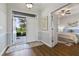 Bright entryway with an open door, hardwood floors, and a glimpse of the main bedroom at 1420 Mickelson Ct, Davenport, FL 33896