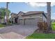 Charming home with brick paver driveway, manicured lawn and a three-car garage at 1420 Mickelson Ct, Davenport, FL 33896