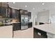 Well-equipped kitchen boasts stainless steel appliances, dark cabinets, and ample countertop space at 1420 Mickelson Ct, Davenport, FL 33896