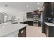 Modern kitchen with stainless steel appliances, white countertop island, and dark cabinetry at 1420 Mickelson Ct, Davenport, FL 33896