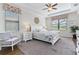 Inviting main bedroom with natural light, a decorative ceiling fan, and a cozy chair at 1420 Mickelson Ct, Davenport, FL 33896