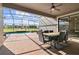 Covered patio featuring brick pavers, a ceiling fan, and a view of the pool and golf course at 1420 Mickelson Ct, Davenport, FL 33896