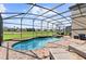 Inviting screened-in pool and spa with a peaceful golf course backdrop at 1420 Mickelson Ct, Davenport, FL 33896