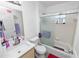 Bright bathroom featuring a shower-tub, single vanity, white tile, and contemporary fixtures at 151 3Rd Ave, Babson Park, FL 33827