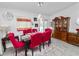 Elegant dining room with a dark wood table, red upholstered chairs, modern chandelier, and wood china cabinet at 151 3Rd Ave, Babson Park, FL 33827