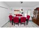 Bright dining area with a dark wood table, six red upholstered chairs, sliding glass door, and wooden china cabinet at 151 3Rd Ave, Babson Park, FL 33827