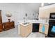 Well-lit kitchen featuring light wood cabinets, white countertops, a stainless steel sink, and black appliances at 151 3Rd Ave, Babson Park, FL 33827