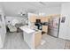 Open kitchen featuring light wood cabinets, stainless steel appliances, and a breakfast bar, flowing into the living area at 151 3Rd Ave, Babson Park, FL 33827