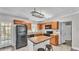 This cozy kitchen is furnished with wooden cabinets, an island, and black appliances at 1518 Avenue C Ne, Winter Haven, FL 33881